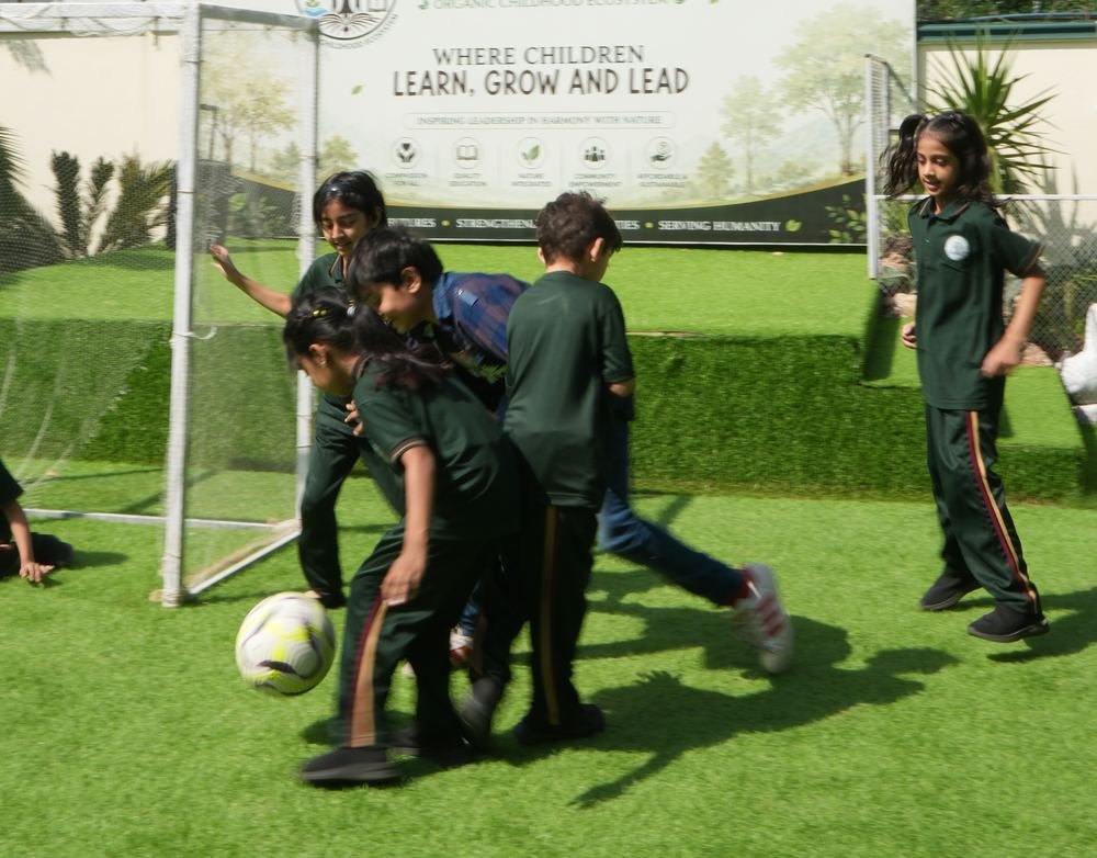 Children playing football on the school field