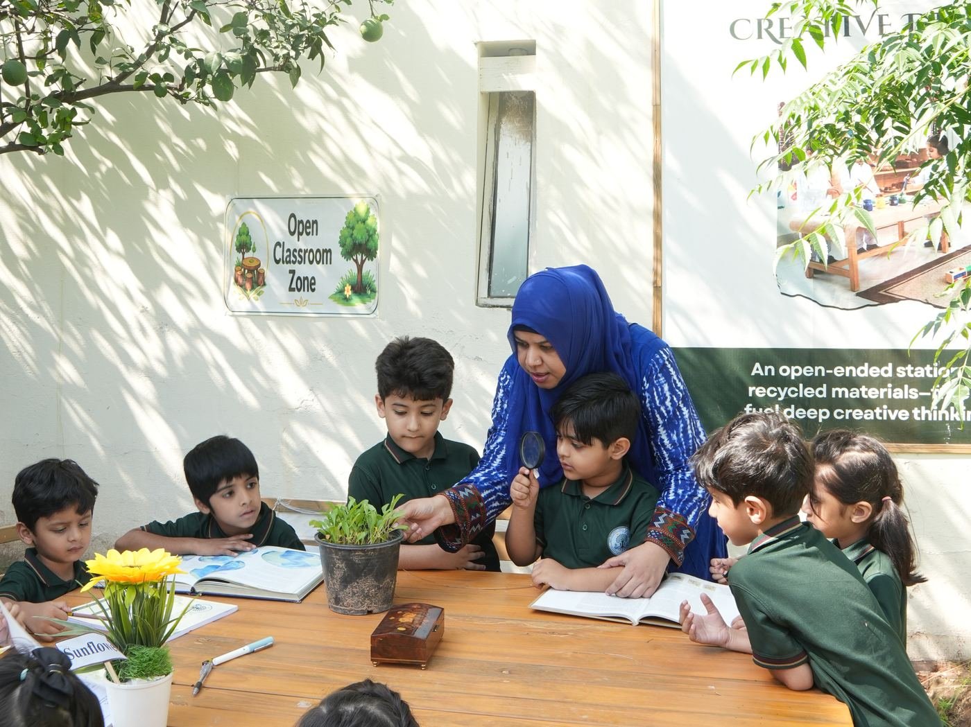 Children studying plants with magnifying glasses and nature journals